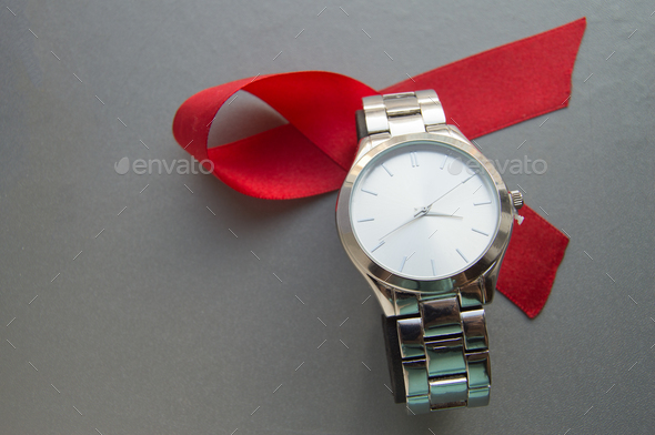 World AIDS day, the symbol of the red ribbon and the clock - do not waste time to start treatment