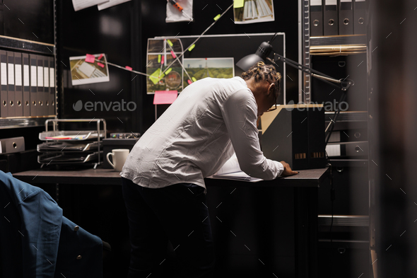 Woman standing near detective desk, reading crime case file