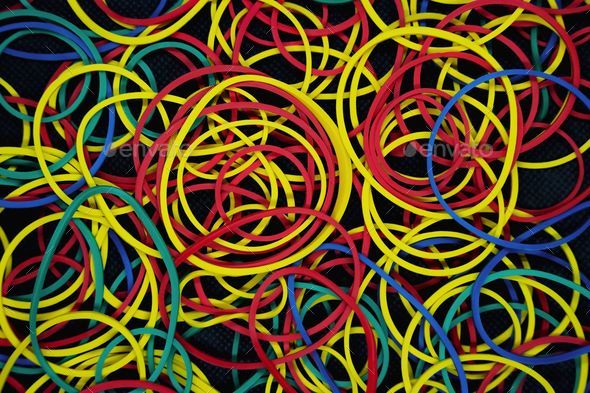 Close up of different colored rubber bands isolated on a black background  Stock Photo by wirestock