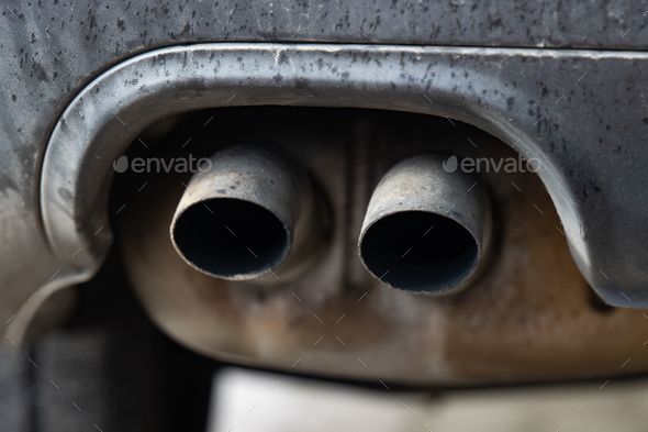 the exhaust pipe is visible from underneath the car's rear end Stock