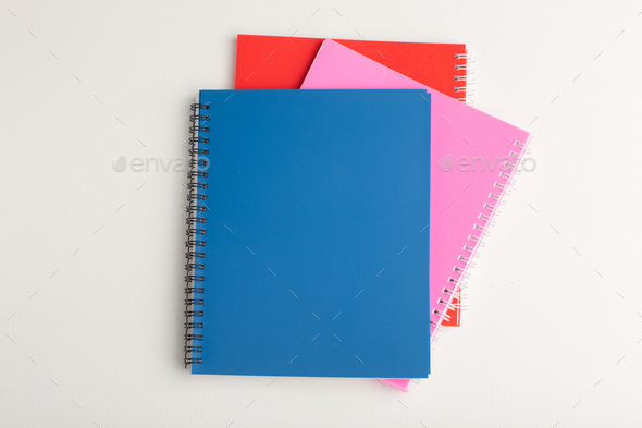 top view different colorful copybooks on the white background school notepad pen photo
