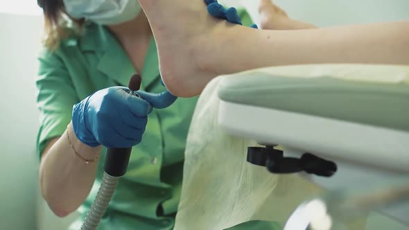 Young Pretty Girl Sits in a Chair in a Beauty Salon She is Given a Pedicure 1 alt