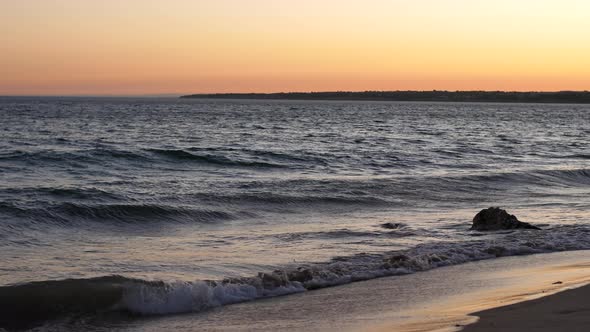 Beautiful Orange Sky Dring Sunset at the Beach. Waves Crashing SLOMO alt
