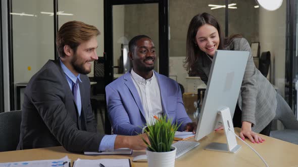 Three Office Workers Business Colleagues Sitting at Desk and Discussing Work alt