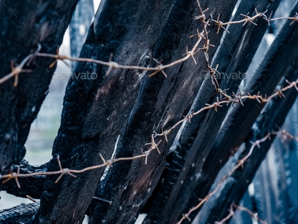 Burnt fence with barbed wire
