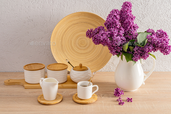 A set of white ceramic jars for bulk products and a cup of morning coffee on the kitchen countertop