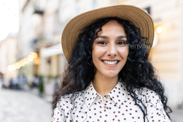 Beautiful Young Latin American Woman Portrait Woman Walking In Evening City In Hat With Curly