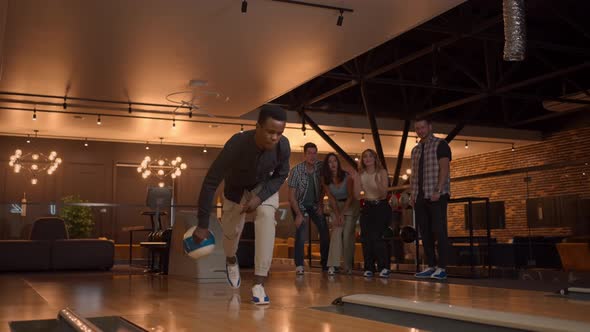 An AfricanAmerican Throws a Bowling Ball and Knocks Out a Shot with One Shot alt