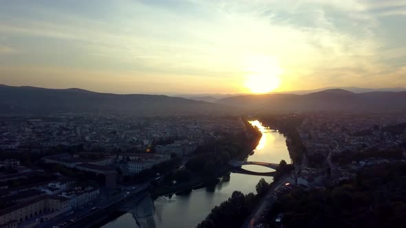 Reno river in Bologna Italy during sunset with lens flare on sun, Aerial left pan shot alt