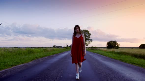 Young Girl Walks Along an Empty Road