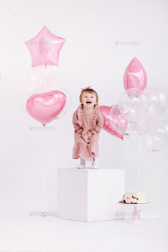 happy birthday 2 years old little girl in pink dress. white cake with ...