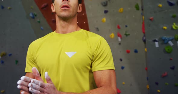 Man Dusting His Hand with Chalk Powder Before Climbing the Artificial Wall 4k alt
