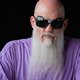 Portrait of man with long gray beard wearing purple t-shirt and sunglasses close-up shot - PhotoDune Item for Sale