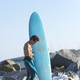 Back view of young surfer standing barefooted on sandy shore, - PhotoDune Item for Sale