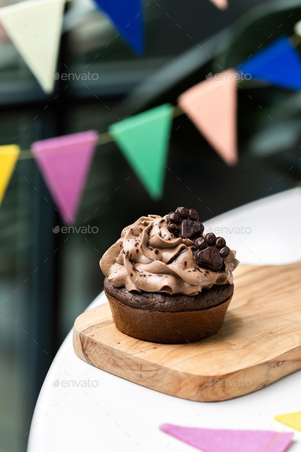 Freshly-baked muffin decorated with a dollop of whipped cream - Stock Photo - Images