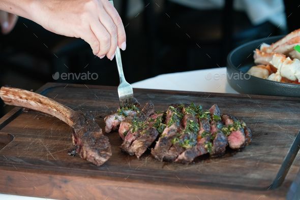 Man cutting meat on chopping board stock photo