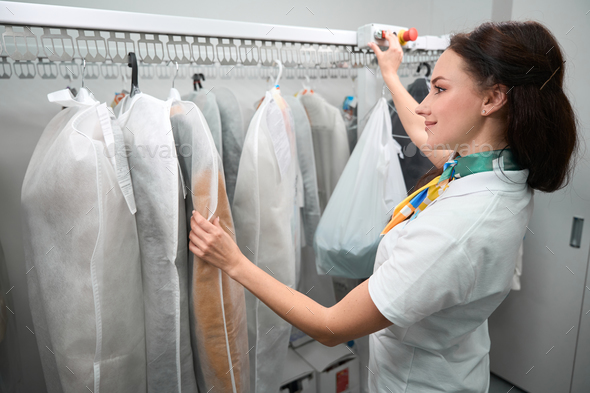 Rack of clean clothes hanging on hangers at dry-cleaning Stock Photo