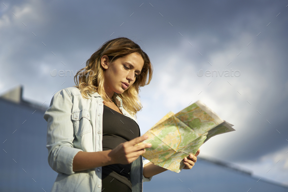 Attractive hipster girl checking location tracking orientation for walking around city during sunn