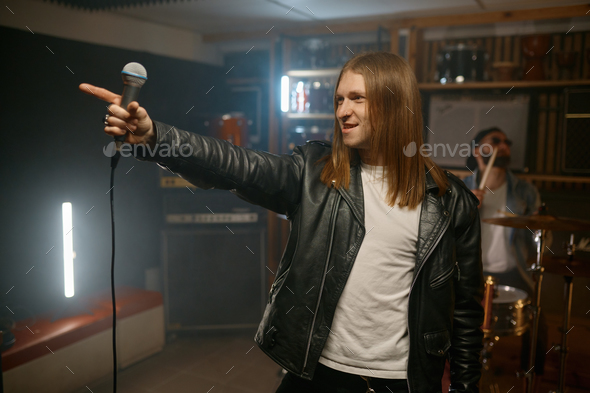 Man rocker wearing style with black jacket and white t-shirt with microphone