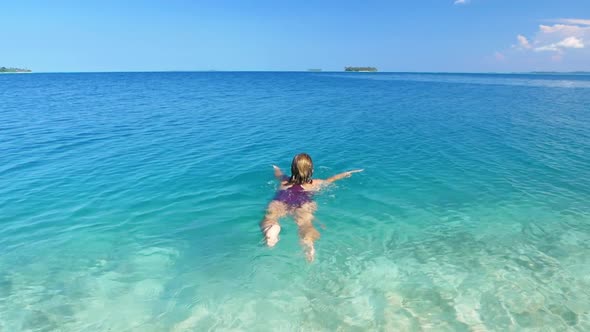 Slow motion: woman swimming in caribbean sea turquoise water, tropical islands, away from it all alt
