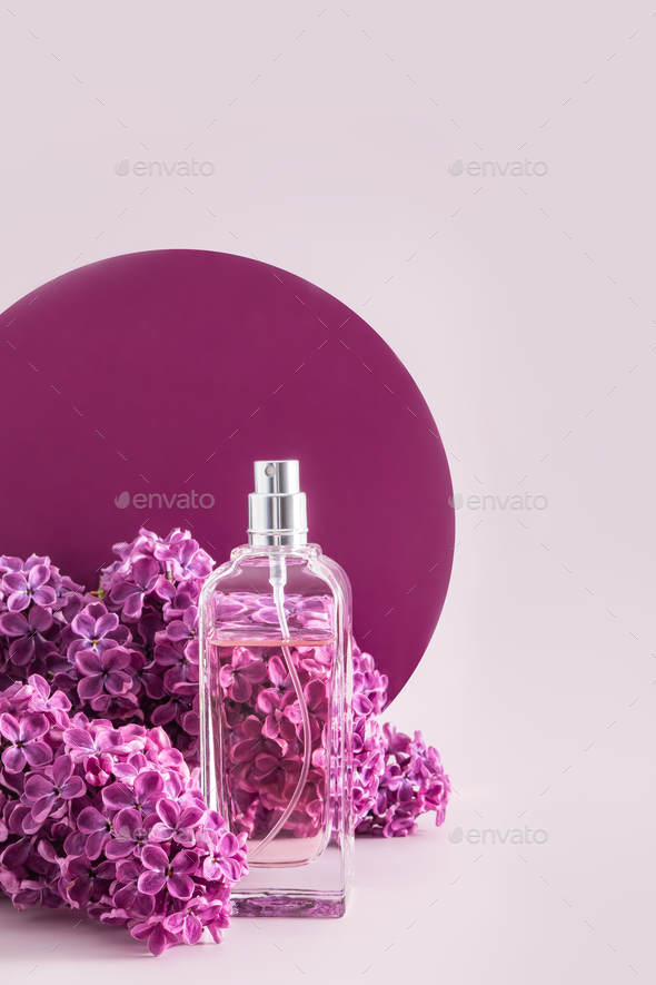 A bottle of cosmetic spray or perfume against a background of lilac flowers and a round catwalk.