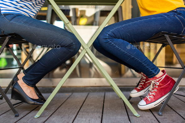 An image of a woman legs sitting on a table. Stock Photo