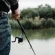 a man with a fishing rod in his hand is looking back at the water Stock  Photo by wirestock