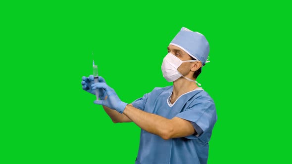 Medic In Mask And Uniform Preparing A Syringe For Injection on Green Screen