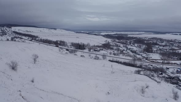 Russian Village in Winter Under a Bright Cloudy Sky