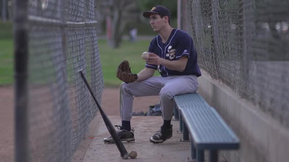 A baseball player resting on the bench. alt