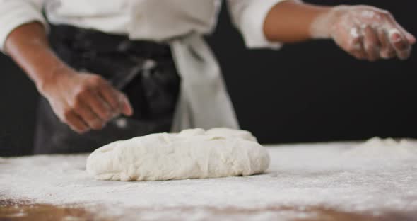 Video of cook throwing flour on the table on black background alt