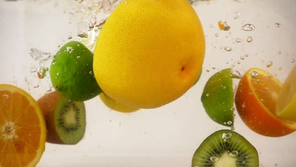 Halves of Different Fruits Falling with Splashes in Water, Multifruit Set, Slow Motion Close-up alt