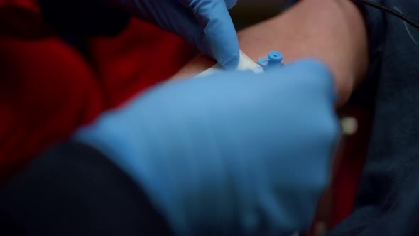 Paramedic Inserting Needle Cannula in Arm alt