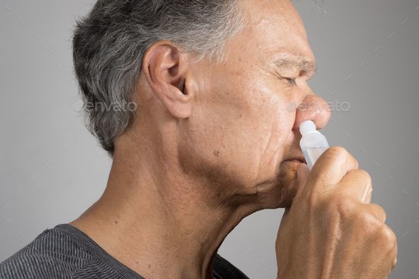 Senior man using a Nasal Spray