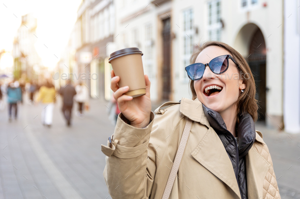Portrait young beautiful happy smiling woman drinking coffee to go tea in eco sustainable paper cup