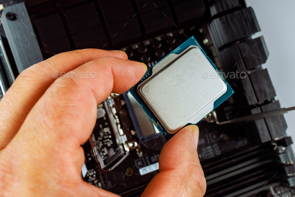 Technician is carefully inserting CPU into motherboard socket during ...