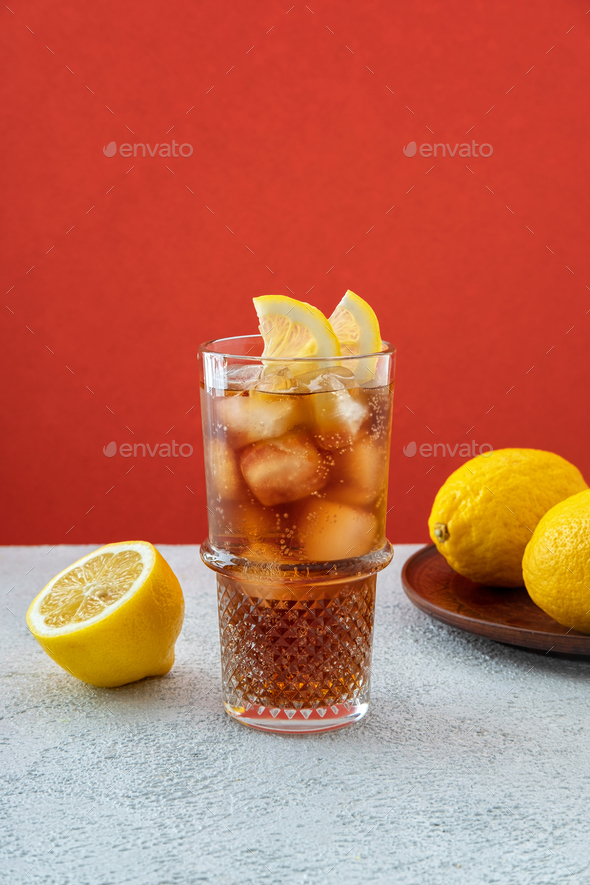 Long Island iced tea cocktail garnished with lemon slice in highball