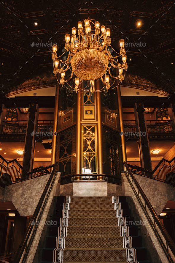 an elaborate chandelier is over the stairs in the lobby of a cruise ship