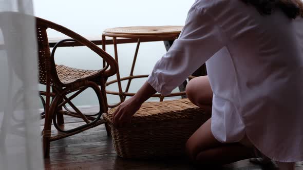 A woman preparing stuffs to make drip coffee with a beautiful nature view on foggy day