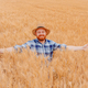 Happy farmer with arms outstretched standing in his growing wheat seeds field. - PhotoDune Item for Sale