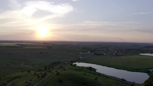 Beautiful Summer Sunset with Lakes and Green Hills