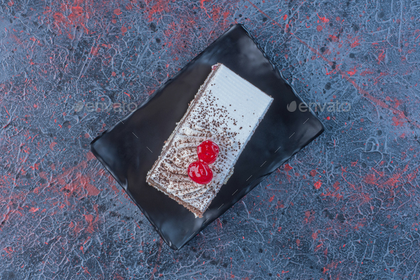 Cherry topped cake on a platter on abstract background