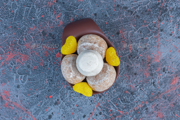 Vanilla powder coated cookies and marmalades in a small bowl on abstract background