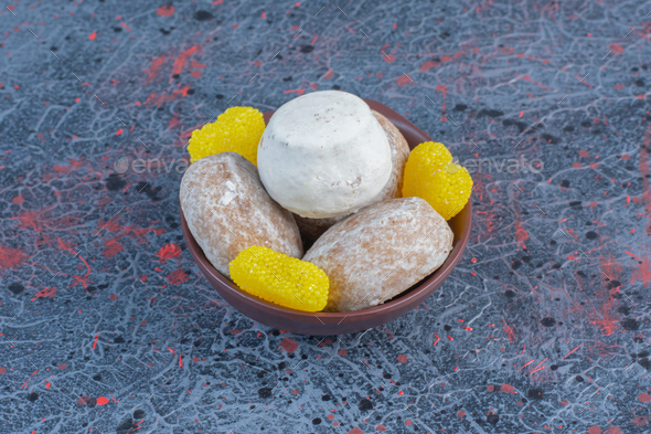 Vanilla powder coated cookies and marmalades in a small bowl on abstract background
