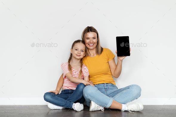 Online Ad. Happy Young Mother And Little Daughter Holding Blank Digital Tablet
