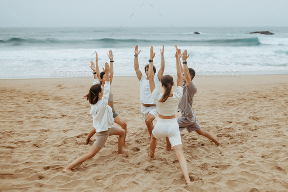 men young yoga by doing on ocean sportswear of and on in Prostock-studio circle standing women in shore, Group mats Stock Photo