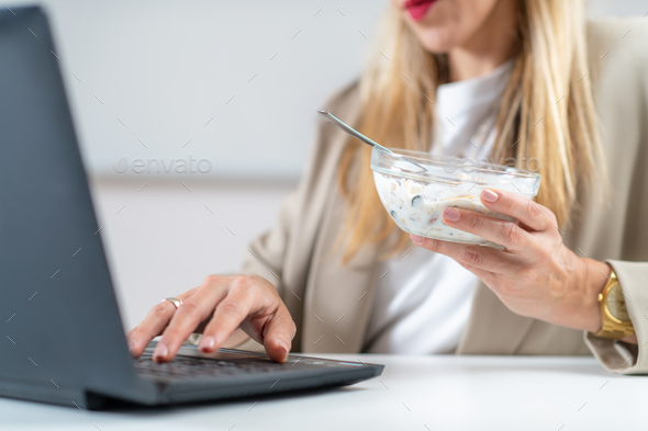 Woman Enjoys Muesli & Yogurt While Working