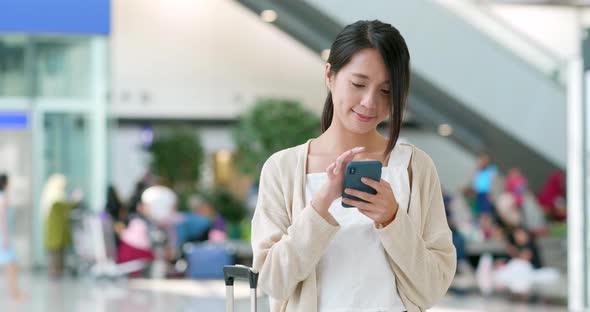 Woman use of smart phone in the airport alt