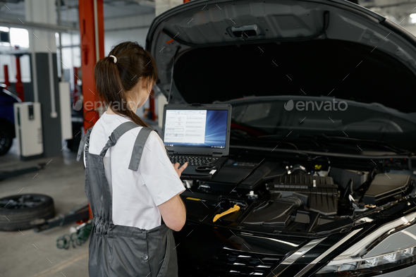 Back view on woman auto engineer doing computer diagnostic Stock Photo by  NomadSoul1