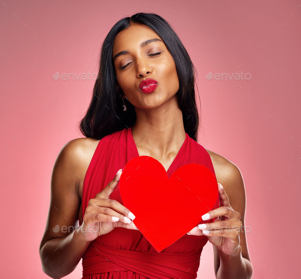 Woman, paper heart and kiss in studio with lips, makeup and beauty with romantic sign by red backgr